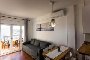 ein Wohnzimmer mit einem Sofa und einem Tisch in der Unterkunft APARTAMENTO PIE DE PLAYA-Wifi free in L'Escala