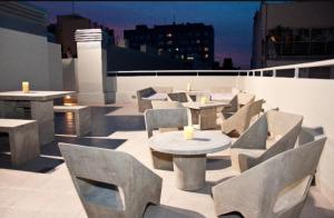 a rooftop patio with tables and chairs on a building at Departamento con pileta Almagro in Buenos Aires