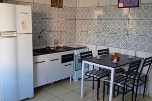 a small kitchen with a table and a refrigerator at Repouso da Cachoeira in Foz do Iguaçu