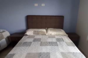 a bedroom with a bed with a checkered bedspread at Repouso da Cachoeira in Foz do Iguaçu