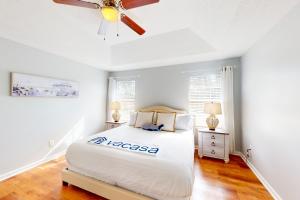 um quarto com uma cama e uma ventoinha de tecto em Wildwood Getaway em Panama City Beach