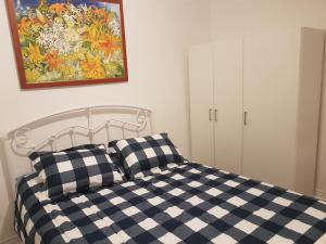 1 dormitorio con cama a cuadros en blanco y negro en A&I Cosy&Bright Apartments near Old Port and South Shore en Longueuil