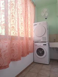 a laundry room with a washing machine and a window at Seafront Apartment in St. Paul's Bay in St Paul's Bay