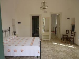 a bedroom with a white bed and a chandelier at Donna Bianca B&B in Specchia