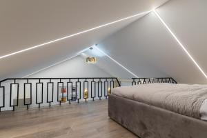 a white room with a bed and a staircase at Amber Stone Apartment 2nd floor in Palanga