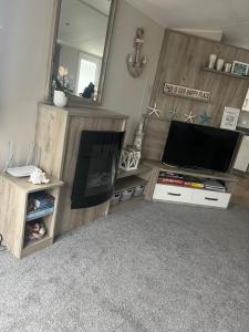 a living room with a television and a mirror at Sky by the sea in Whitstable