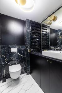 a black bathroom with a toilet and a sink at Amber Stone Apartment 2nd floor in Palanga +28 photos