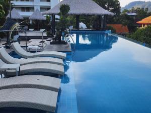 a swimming pool with lounge chairs and a hotel at Andaman sea view private in Patong Beach