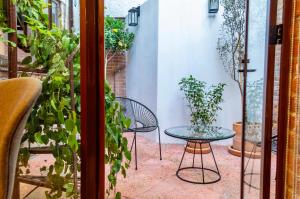 eine Terrasse mit einem Tisch, Stühlen und Pflanzen in der Unterkunft Mi Zona Lodging Coyoacán in Mexiko-Stadt