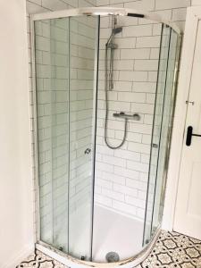 a shower with a glass door in a bathroom at Cosy House, Lisburn Road in Belfast