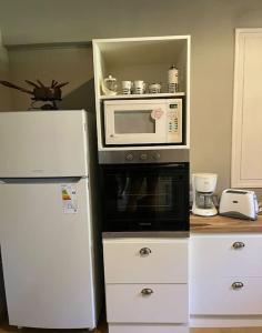 a kitchen with a microwave and a refrigerator at Casa Campo - Altamira in Campo Los Andes