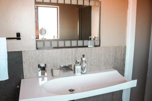 a bathroom with a white sink and a mirror at Modern Home in Pretoria in Pretoria
