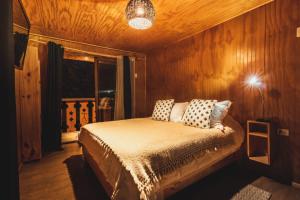 - une chambre avec un lit et des oreillers dans l'établissement Hostel Antawara, à Vicuña