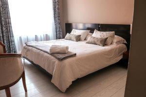 a bedroom with a large bed with white sheets and pillows at Modern Home in Pretoria in Pretoria