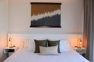 1 dormitorio con 1 cama blanca con almohadas y 2 lámparas en Singular Dream Vacation Rentals en Playa del Carmen