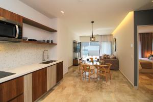 cocina y sala de estar con mesa y sofá en Singular Dream Vacation Rentals en Playa del Carmen