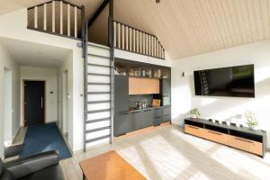 a living room with a staircase leading up to a loft at Tartu Pajuoja saunamaja in Tartu