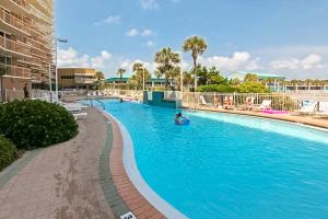 una piscina en un complejo con una persona nadando en él en The Terrace at Pelican Beach 504 en Destin