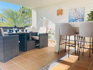 une salle à manger avec des chaises en osier et une table dans l'établissement Blue Palm Apartment Estepona, à Estepona