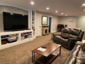 sala de estar con sofá y TV grande en High Quality 3200sqft House, Pool Table, Laundry, en Murray