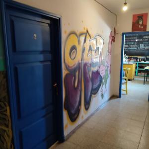 une porte bleue dans une pièce avec un mur recouvert de graffitis dans l'établissement rafa's house, à Mendoza