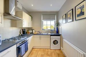 een keuken met een wastafel en een wasmachine. bij Regency Nest by Spa Town Property - Stylish 3 Bedroom Apartment on 2 Floors, Central Leamington Spa in Leamington Spa