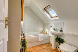 La salle de bains est pourvue d'un lavabo, de toilettes et d'une baignoire. dans l'établissement Regency Nest by Spa Town Property - Stylish 3 Bedroom Apartment on 2 Floors, Central Leamington Spa, à Leamington Spa