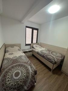 1 Schlafzimmer mit 2 Betten und einem Fenster in der Unterkunft Къща за гости Елит (Guest House Elite) in Saparewa Banja