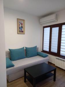 ein Sofa mit blauen Kissen im Wohnzimmer in der Unterkunft Къща за гости Елит (Guest House Elite) in Saparewa Banja