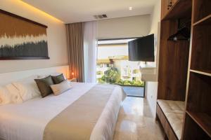 1 dormitorio con 1 cama grande y TV en Singular Dream Vacation Rentals en Playa del Carmen
