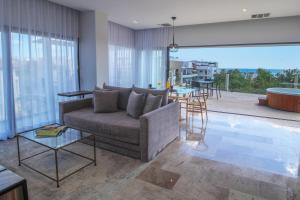 ein Wohnzimmer mit Sofa und Tisch in der Unterkunft Singular Dream Vacation Rentals in Playa del Carmen