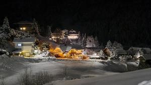 a house is lit up in the snow at night at Chalet Catina in Bad Kleinkirchheim