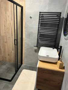 a bathroom with a white sink and a shower at Apartamenty Slowianka in Wolibórz