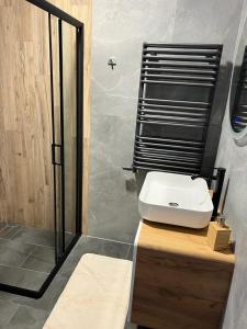łazienka z białą umywalką i prysznicem w obiekcie Apartamenty Slowianka w mieście Wolibórz