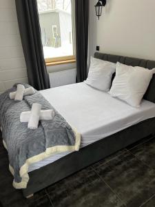 łóżko z dwoma ręcznikami i oknem w obiekcie Apartamenty Slowianka w mieście Wolibórz