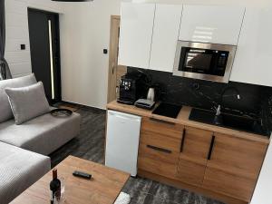 salon z kanapą i kuchnią w obiekcie Apartamenty Slowianka w mieście Wolibórz