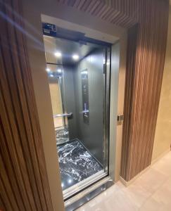 a bathroom with a glass door with a walk in shower at Appartement Cosy et chaleureux - Casablanca centre in Casablanca
