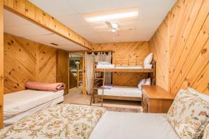 a room with wooden walls and bunk beds at The River Retreat in Thompsonville