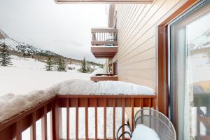 a balcony with a snow covered bench and a window at Skyland Studio in Crested Butte