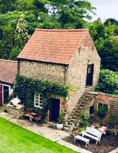 una pequeña casa de ladrillo con un patio en The Barn at Providence Cottage en Alkborough