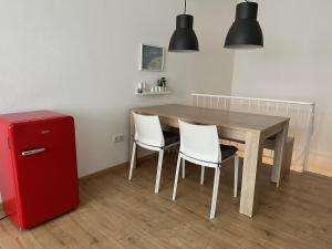 tavolo da pranzo con 2 sedie e frigorifero rosso di Nordseekrabbe a Norderney