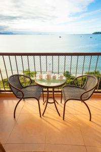 una mesa y sillas en un balcón con vistas al océano en Jurerê Beach Village, en Florianópolis