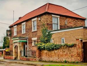 una casa de ladrillo con techo rojo en The Barn at Providence Cottage en Alkborough