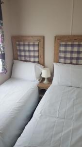 two beds sitting next to each other in a bedroom at CCT Caravan in Turnberry