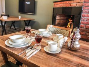 a wooden table with plates and glasses and a fireplace at Casavilla Kartalkaya in Kındıra