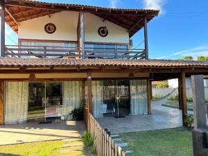 a large house with a wooden roof at Flats Corumbau in Corumbau