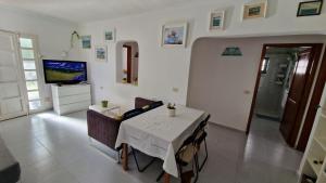 a dining room with a white table and a television at Chelada 2 in Arrieta