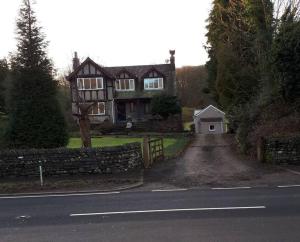 uma casa ao lado de uma estrada em Tudor Cottage, Newby Bridge em Ulverston