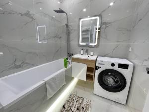 キシナウにあるCozy apartment in a very developed area!の洗濯機と洗面台を備えたバスルーム +9枚の写真
