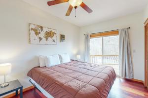 um quarto com uma cama, uma ventoinha de tecto e uma janela em Emerald Cove em Eureka Springs